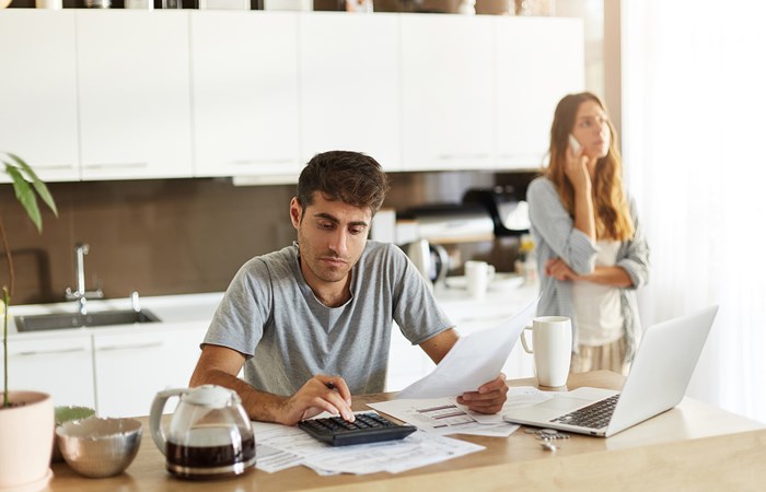 Couple looking over a bill and on the phone